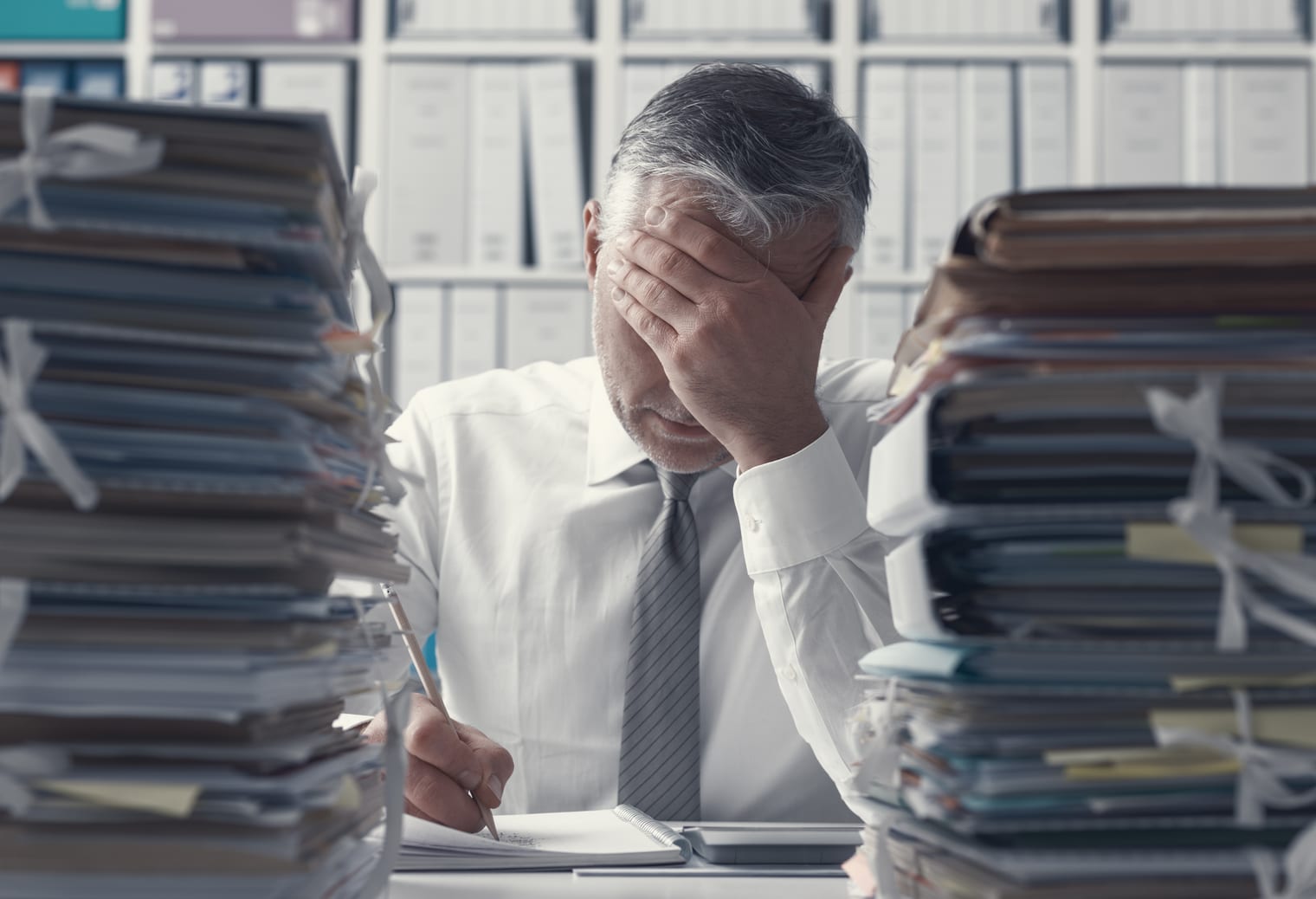 上班族被辦公桌上成堆的文件淹沒